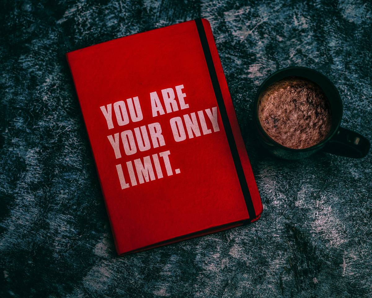 handwritten growing self quotes journal next to budget tracker showing real growth